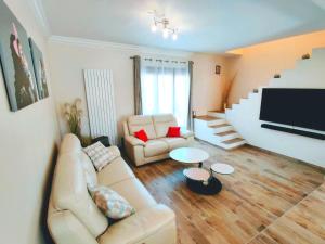 a living room with a couch and a table at Maison 190m2 - Entre Paris et Disneyland in Gagny