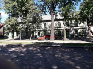 un edificio con un coche rojo estacionado frente a él en Sun Boat Apartments en Ventspils