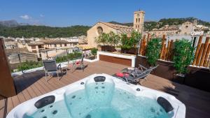 uma banheira de hidromassagem numa varanda com vista para a cidade em Juma Historic Hotel em Pollença