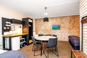 a room with a table and chairs and a bedroom at River Street Motel in Ballina