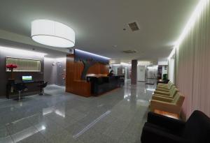 a lobby with chairs and a desk in a building at Hotel Azinheira in Fátima