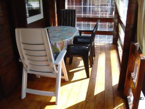 Zimmer mit einem Tisch und Stühlen auf einer Veranda in der Unterkunft Chalet 66 in Porlezza