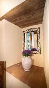 un jarrón sentado en un estante en una habitación con espejo en Villa Cerciano, en Radicondoli