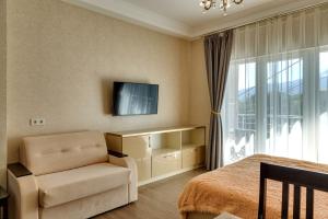 1 dormitorio con 1 cama, 1 silla y TV en Apartment on Morskoy spusk 5, en Yalta