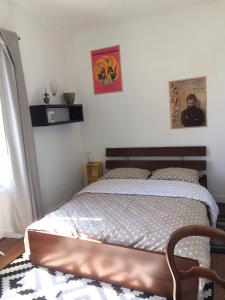 1 dormitorio con 1 cama y 2 cuadros en la pared en La Maison, en Les Forges