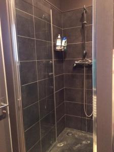 baño con ducha y puerta de cristal en La Maison, en Les Forges