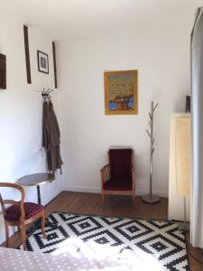 ein Wohnzimmer mit 2 Stühlen und einem Tisch in der Unterkunft La Maison in Les Forges