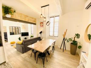 sala de estar con mesa y sofá en Feel@Home Nemausus « Le 4 » en Nimes