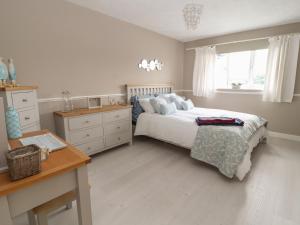 a bedroom with a bed and a desk and a window at Castle View in Conwy