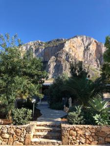 a building with a mountain in the background at Case Cala Bucerno in Castelluzzo