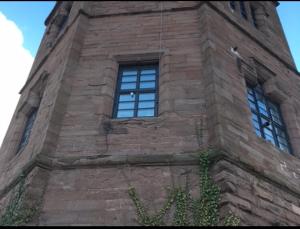 une grande tour en briques avec des fenêtres sur un bâtiment dans l'établissement Montrose Watertower, à Montrose