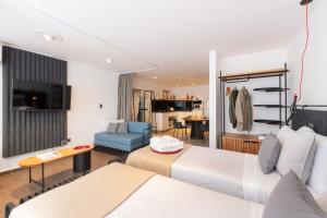 Habitación de hotel con 2 camas y sala de estar. en Stay Suites en Córdoba