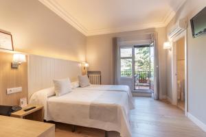 een slaapkamer met een groot wit bed en een raam bij Hotel Artaza in Getxo