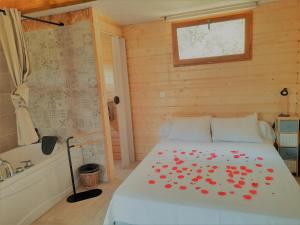 een slaapkamer met een bed met rode bloemen erop bij Cabane dans les arbres "La Kaz aux Cigales" in Cuers
