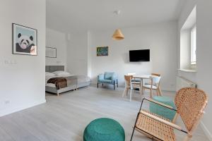 ein Wohnzimmer mit einem Bett, einem Tisch und Stühlen in der Unterkunft Laguna Centrum by Grand Apartments in Sopot