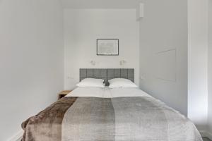 ソポトにあるLaguna Centrum by Grand Apartmentsの白い壁のベッドルーム1室(大型ベッド1台付)