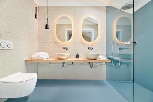 a bathroom with two sinks and two mirrors at Ribarska Koliba Resort in Pula