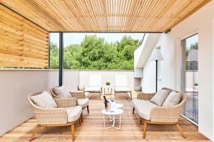 a living room with rattan furniture and a large window at Ribarska Koliba Resort in Pula