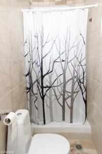a bathroom with a shower curtain with trees at Luxury Apartment in Nikiti