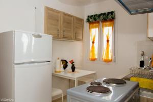 a kitchen with a white refrigerator and a stove at Luxury Apartment in Nikiti