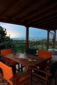 een houten tafel en stoelen op een balkon met uitzicht bij Luxury Apartment in Nikiti