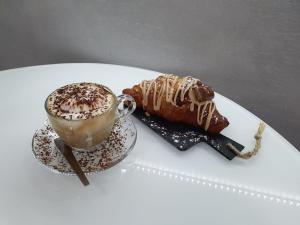 a cup of coffee and a pastry on a white plate at Le stanze di Dalia in Crotone