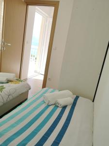1 dormitorio con 2 camas con rayas blancas y azules en Apartments Panorama, en Trpanj