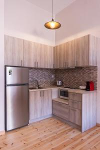 a kitchen with wooden cabinets and a stainless steel refrigerator at MARKOS LUXURY APARTMENTS in Koroni