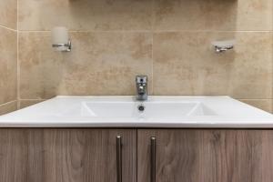 a bathroom with a white sink in a bathroom at MARKOS LUXURY APARTMENTS in Koroni