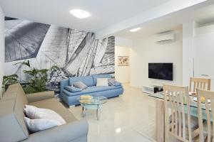 sala de estar con sofá azul y TV en Hedera Estate, Hedera A36, en Dubrovnik