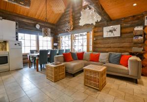 un soggiorno con divano e tavolo di Ylläshilla Cottage ad Äkäslompolo