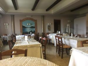 una sala da pranzo con tavoli e sedie con tovaglia bianca di Albergo La Pineta a Cingoli
