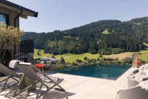 a pool with chairs and a view of a mountain at GOING TRIPLE A apartments EAST in Going am Wilden Kaiser