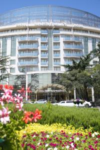 a large white building with flowers in front of it at Звездный Отель WELLNESS & SPA in Sochi