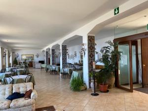 un vestíbulo con mesas y sillas y una habitación en Hotel Villa San Giovanni, en Erice