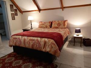 - une chambre avec un grand lit et une couverture rouge dans l'établissement Clarens Mountain Sage Holiday House, à Clarens