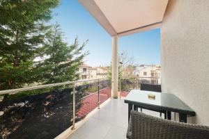 een balkon met een tafel en stoelen en een boom bij Ribarska Koliba - Stella Adria Villa in Pula