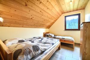 Łóżko w pokoju z drewnianym sufitem w obiekcie SŁONECZNE DOMKI w Istebnej