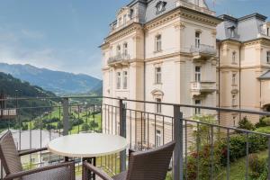 a balcony with chairs and a table in front of a building at Hapimag Ferienwohnungen Bad Gastein in Bad Gastein