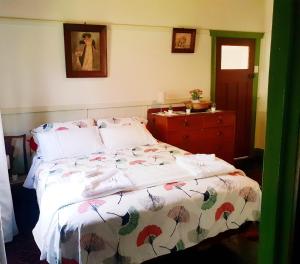 a bedroom with a bed and a dresser at UNIQUE 1920's Historic Retreat! Pet Friendly! in Springwood