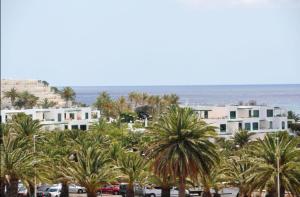 eine Gruppe von Palmen vor einem Gebäude in der Unterkunft Casa el mar in Costa Teguise
