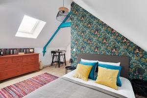 a bedroom with a bed with a large headboard at Le Cotissois in Lanvallay