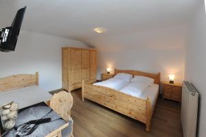 a bedroom with two beds and a television in it at Chalet Gloria - Doppel- und Mehrbettzimmer in Bruck an der Großglocknerstraße