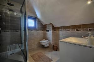 un bagno con wc, lavandino e doccia di SŁONECZNE DOMKI a Istebna 1 altra foto