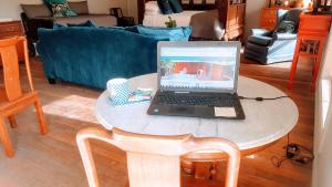 a laptop computer sitting on a table in a living room at The FarmShed Private Retreat McLaren Vale in Clarendon