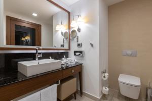 a bathroom with a toilet, sink, and bathtub at Imeretinskiy Hotel in Adler