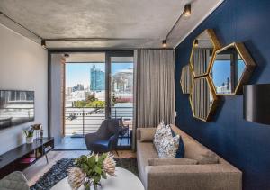ケープタウンにあるDocklands Deluxe One Bedroom Apartments by ITC Hospitalityのソファと大きな窓のあるリビングルーム