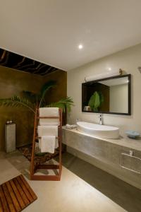 a bathroom with a sink and a large mirror at STUTHI VILLA in Ahangama