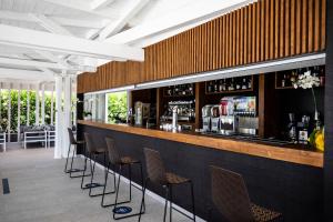 um bar com uma fila de bancos de bar em Valtur Il Cormorano Resort & Spa em Grisolia
