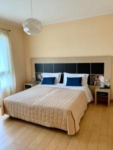 - une chambre avec un grand lit et des oreillers bleus dans l'établissement Hotel Diana, à Ravenne